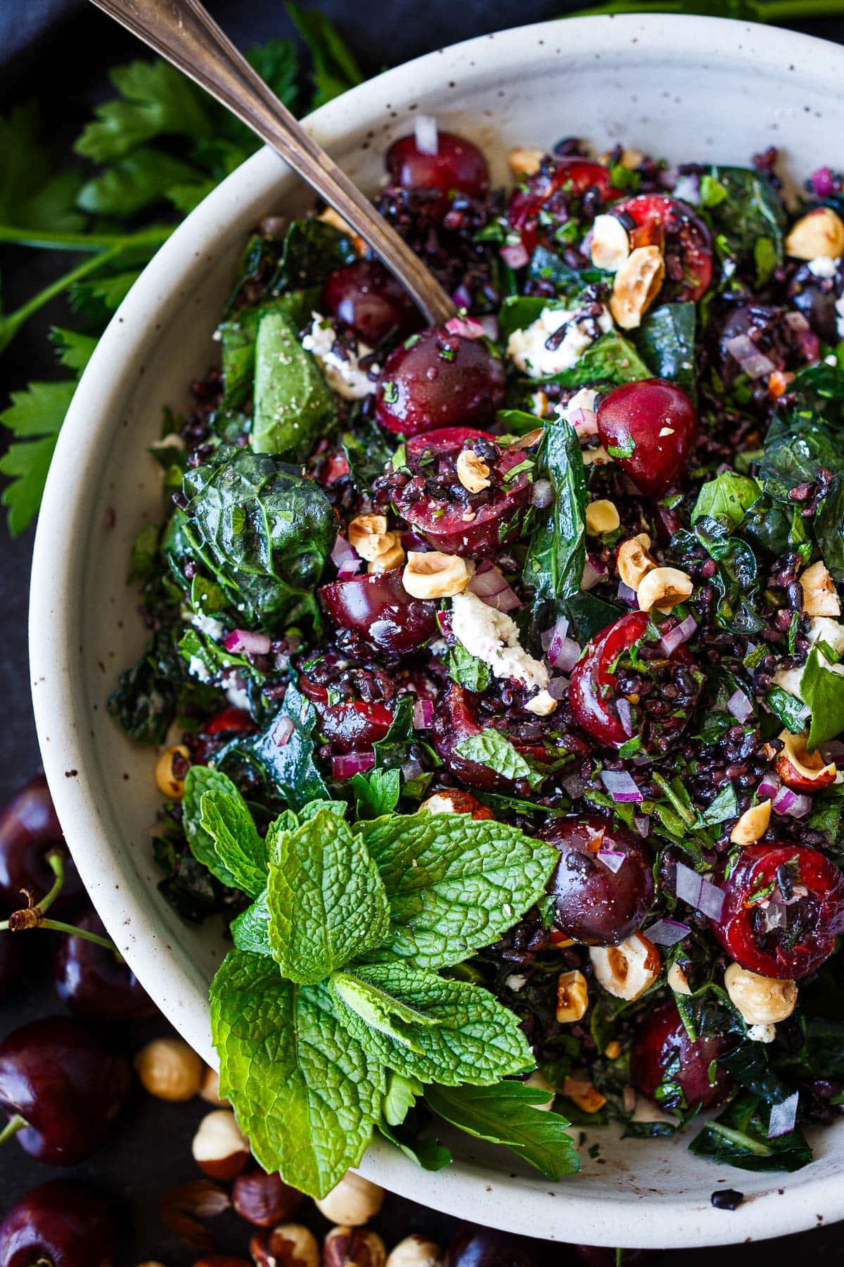 cherry salad with kale and black rice, topped with minced red onion, toasted hazelnuts, and goat cheese.