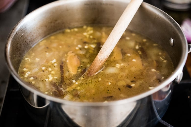 vegan ramen broth vegan ramen broth with garlic and shiitakes and wood spoon.