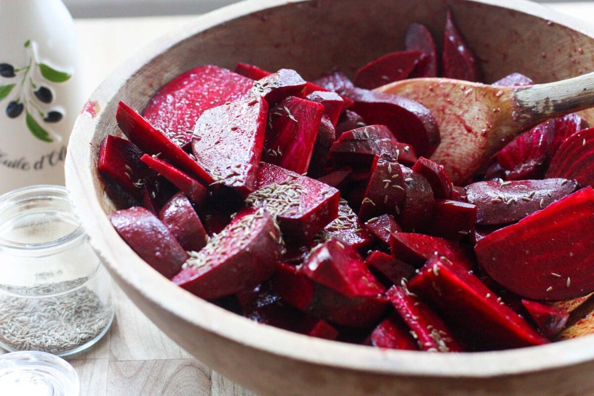 Tossing beets in a bowl with olive oil and seasonings. 