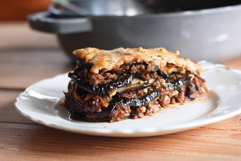 An authentic, delicious recipe for Eggplant Moussaka- with a Tomato lamb sauce, and creamy béchamel sauce. Vegetarian Adaptable! Can be made ahead and baked prior to serving.#eggplantmoussaka