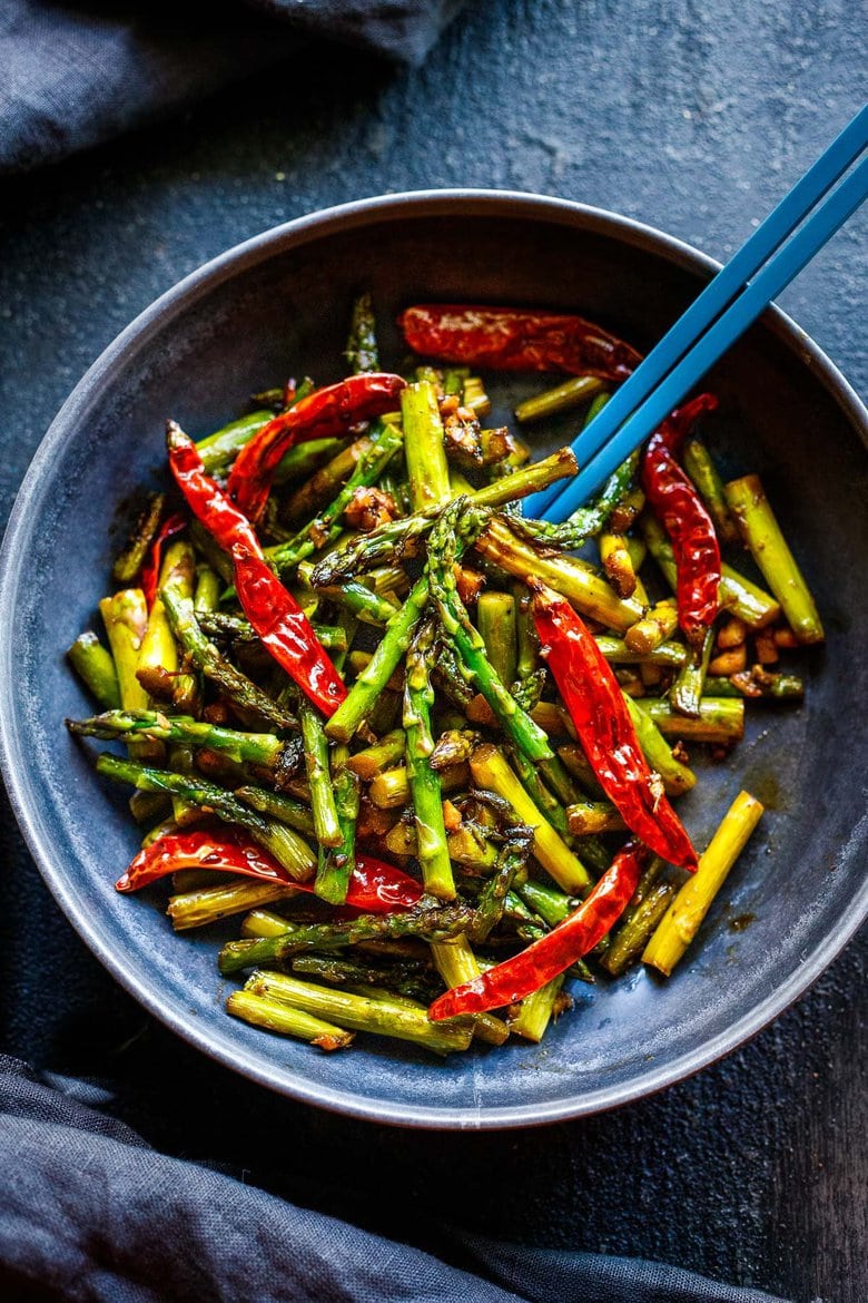 Stir-Fried Asparagus with garlic, ginger, dried chilies and Szechuan sauce - a fast, easy vegan side dish that will spice up your dinner. Serve it with rice and crispy tofu (or chicken), and it becomes a quick and flavorful meal.