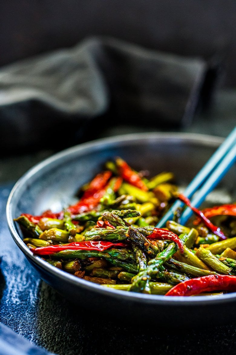 Stir-Fried Asparagus with garlic, ginger, dried chilies and Szechuan sauce - a fast, easy vegan side dish that will spice up your dinner. Serve it with rice and crispy tofu (or chicken), and it becomes a quick and flavorful meal.