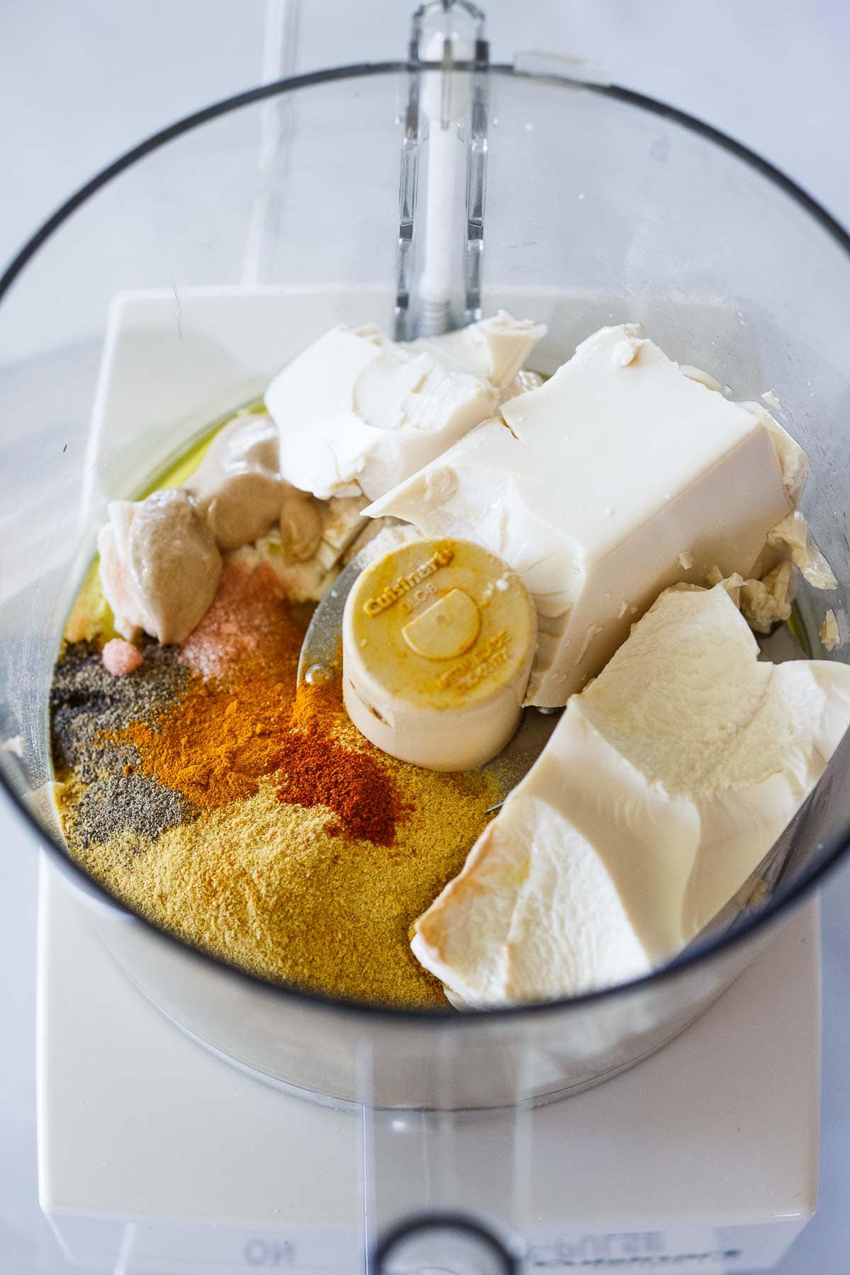 food processor with ingredients for vegan mac and cheese sauce - silken tofu, nutritional yeast, spices, dijon. 