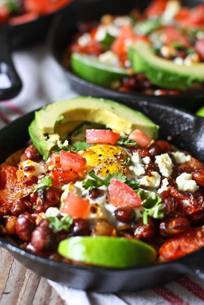 Huevos Rancheros Skillet Eggs- with hearty beans, crispy tortilla, avocado and fresh tomato and cilantro...so simple and tasty! | www.feastingathome.com
