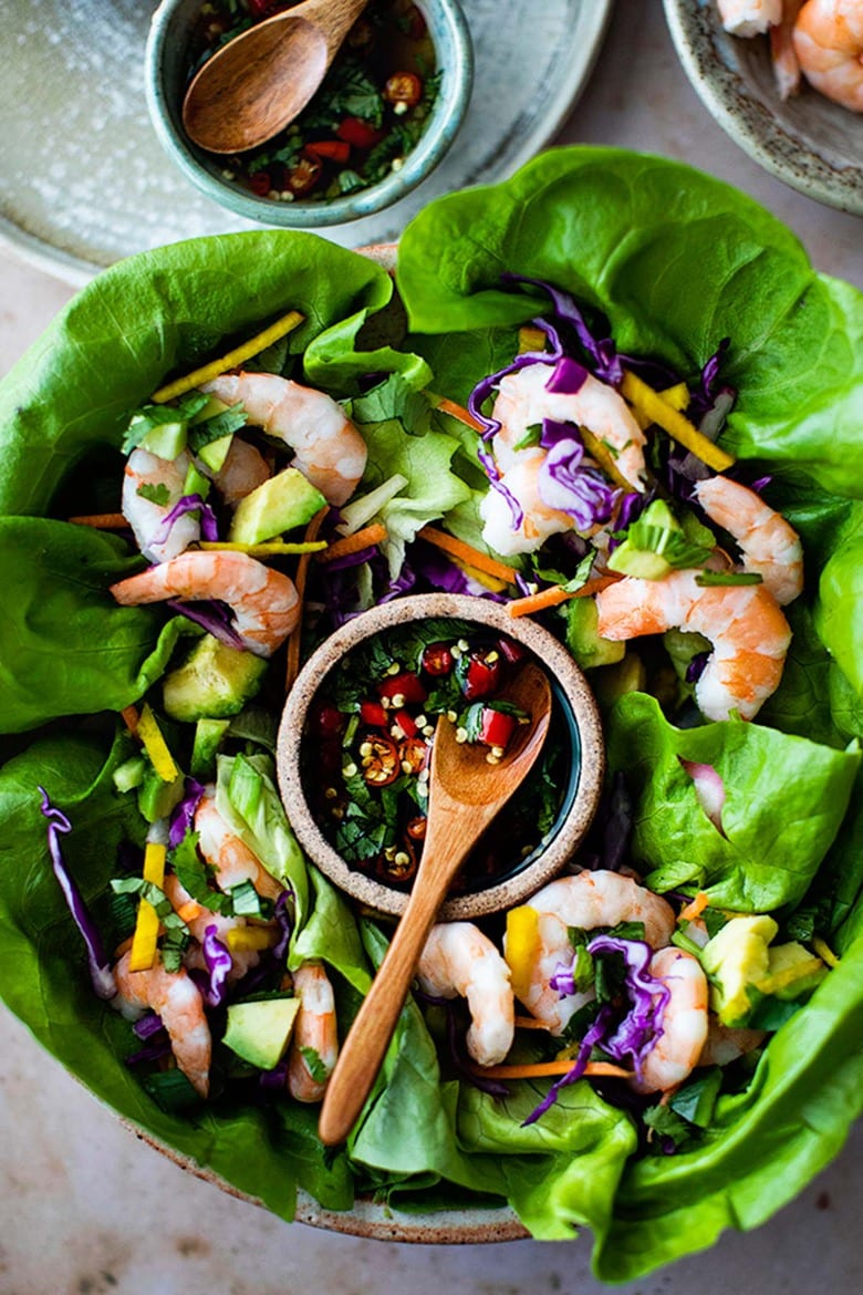 Vietnamese Shrimp Lettuce Wraps on plate surrounding small bowl with Nuoc Cham and small wooden spoon.