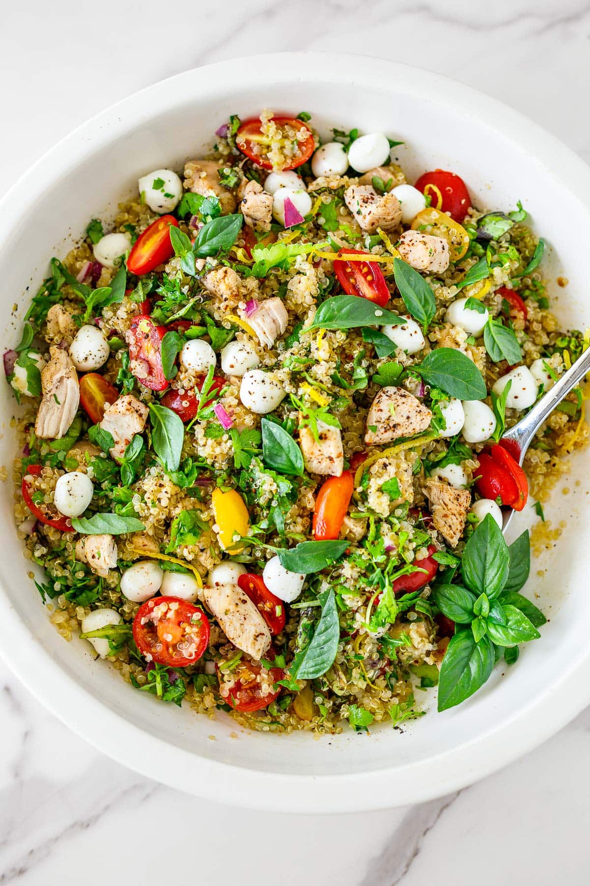 Chicken quinoa salad in a white bowl. 
