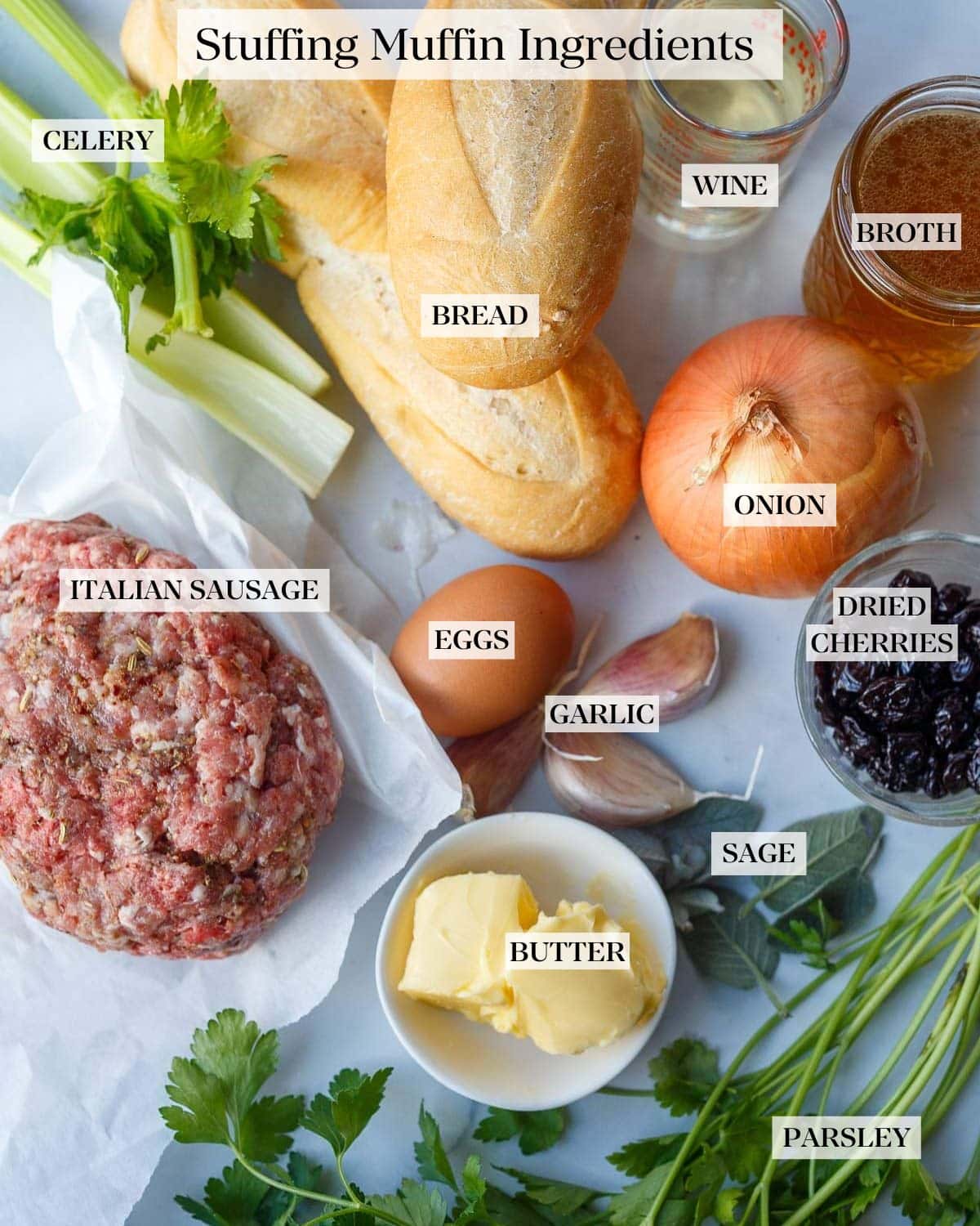 Ingredients layed out on counter: celery, bread, wine, broth, onion, dried cherries, eggs, sausage, garlic, sage, butter, parsley.