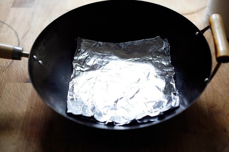 placing 4 layers of foil in a wok.