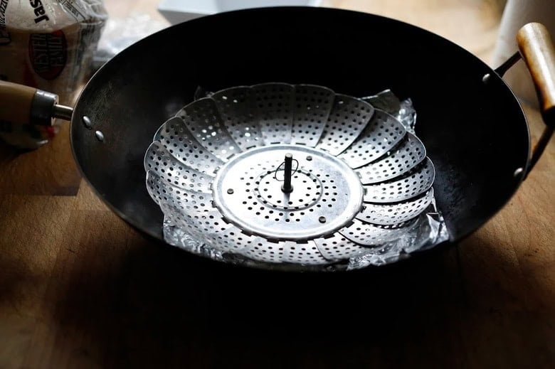 setting up the wok with the foil and steamer basket