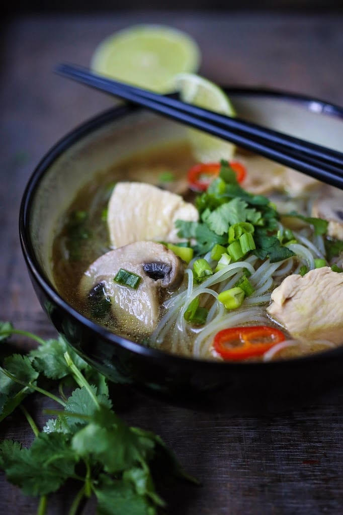 A steaming bowl of Thai Chicken Noodle Soup infused with lemongrass and ginger. A healthy, low fat, gluten-free meal, full of amazing Thai flavors!