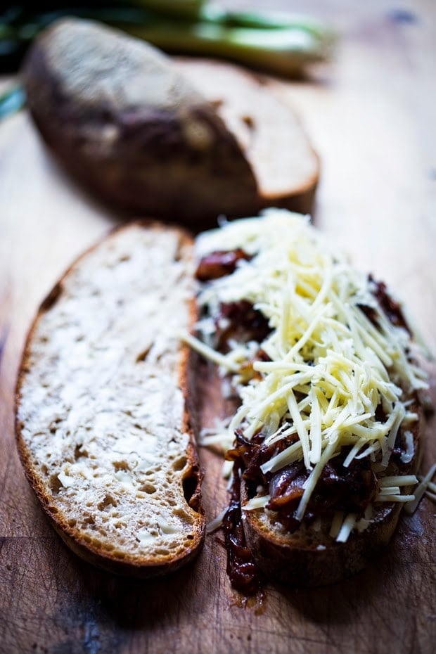 two slices of bread - one with butter, the other with layers of gruyere, caramelized onions, and more gruyere. 