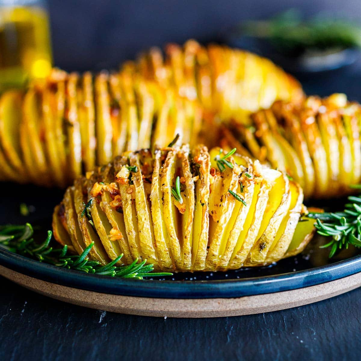 This recipe for hasselback potatoes uses just a few simple ingredients. The potatoes are thinly sliced and stuffed with a generous amount of garlic and rosemary. Drizzled with olive oil, sprinkled with salt and pepper, and then baked in a hot oven for about an hour, they come out tender and perfectly crispy.