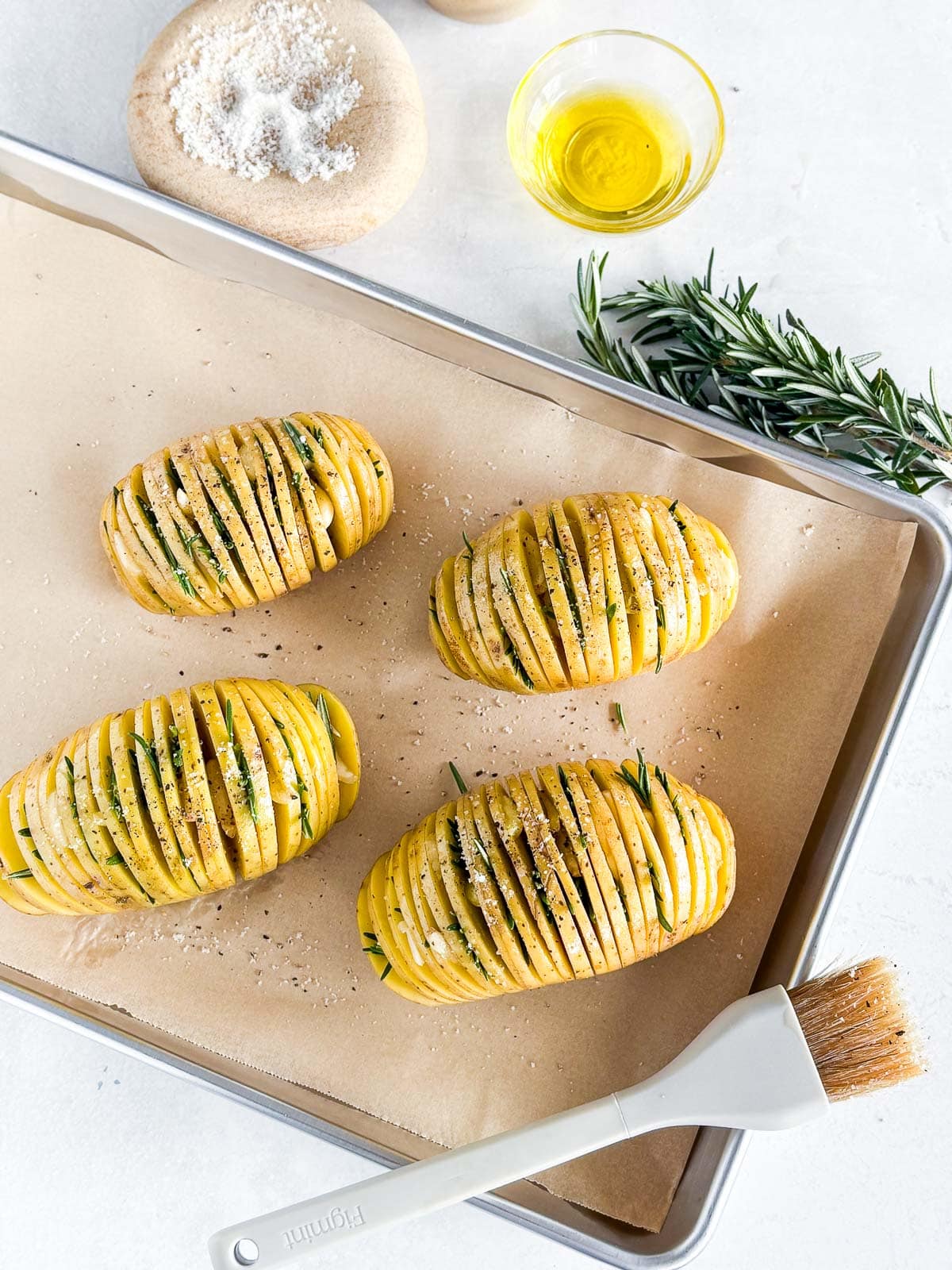 Hasselback Potatoes on a sheet pan about to bake.
