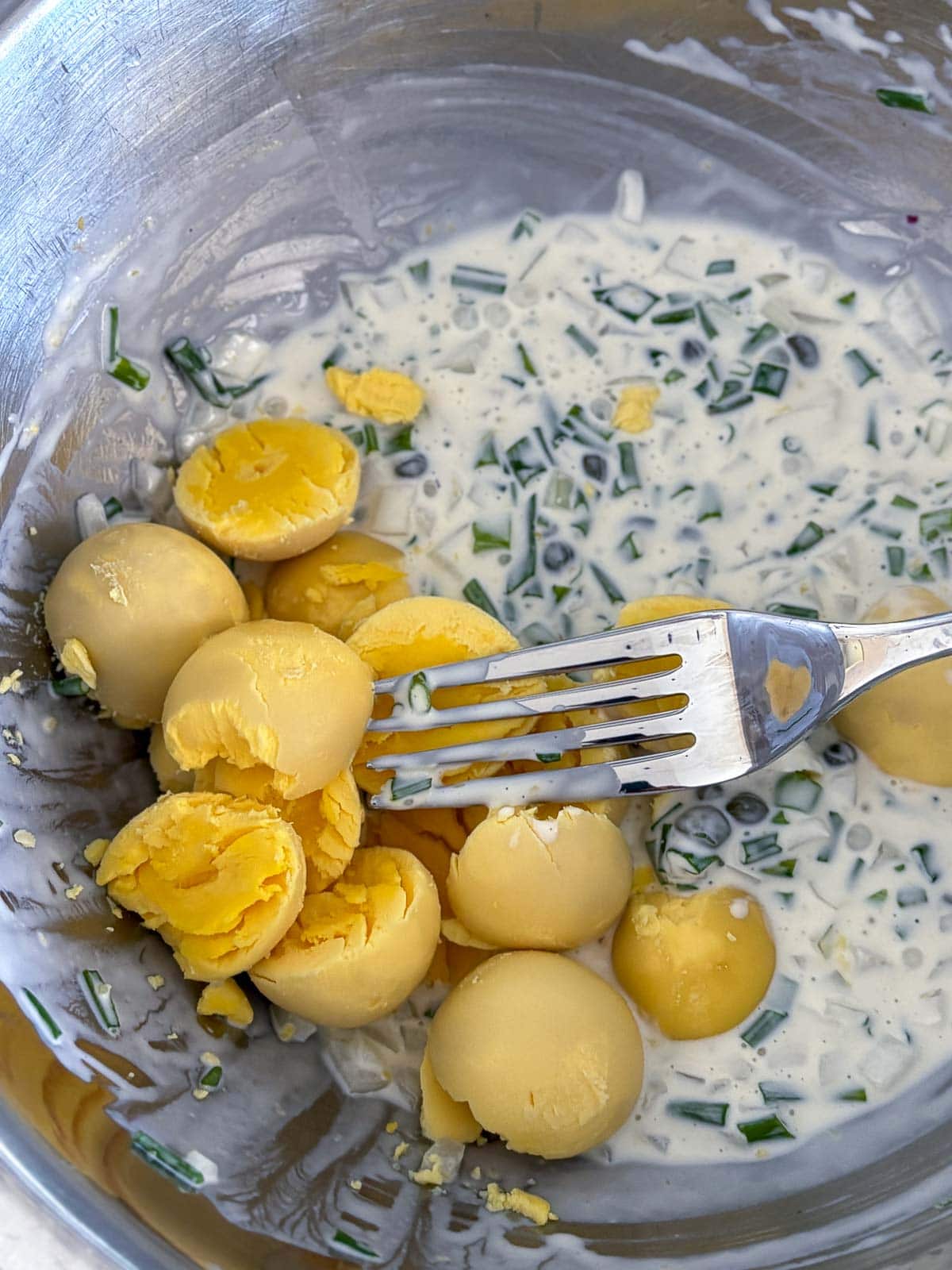 Mashing the yolks into the yogurt mixture.  