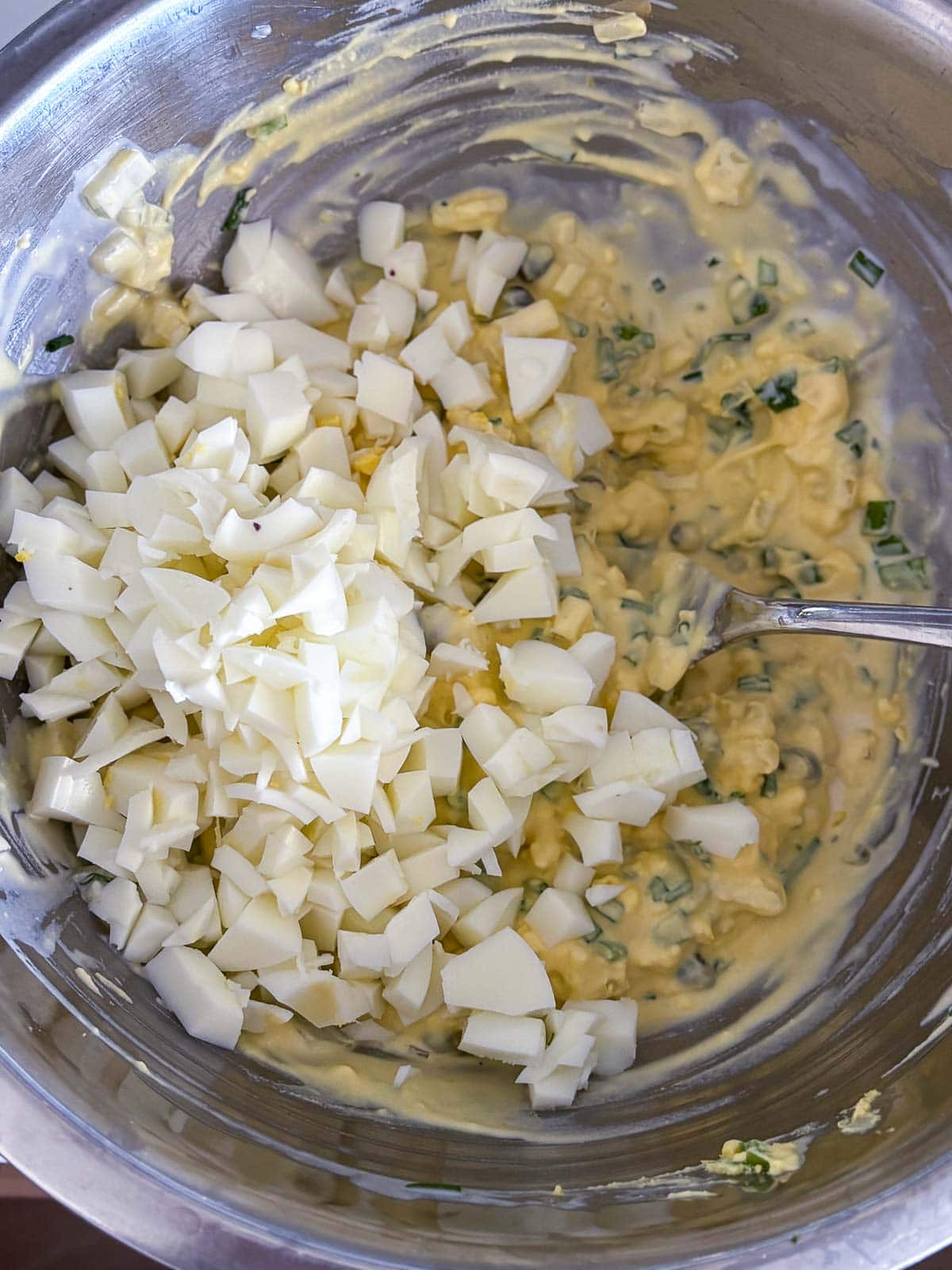 folding in the egg whites to the egg salad mixture. 