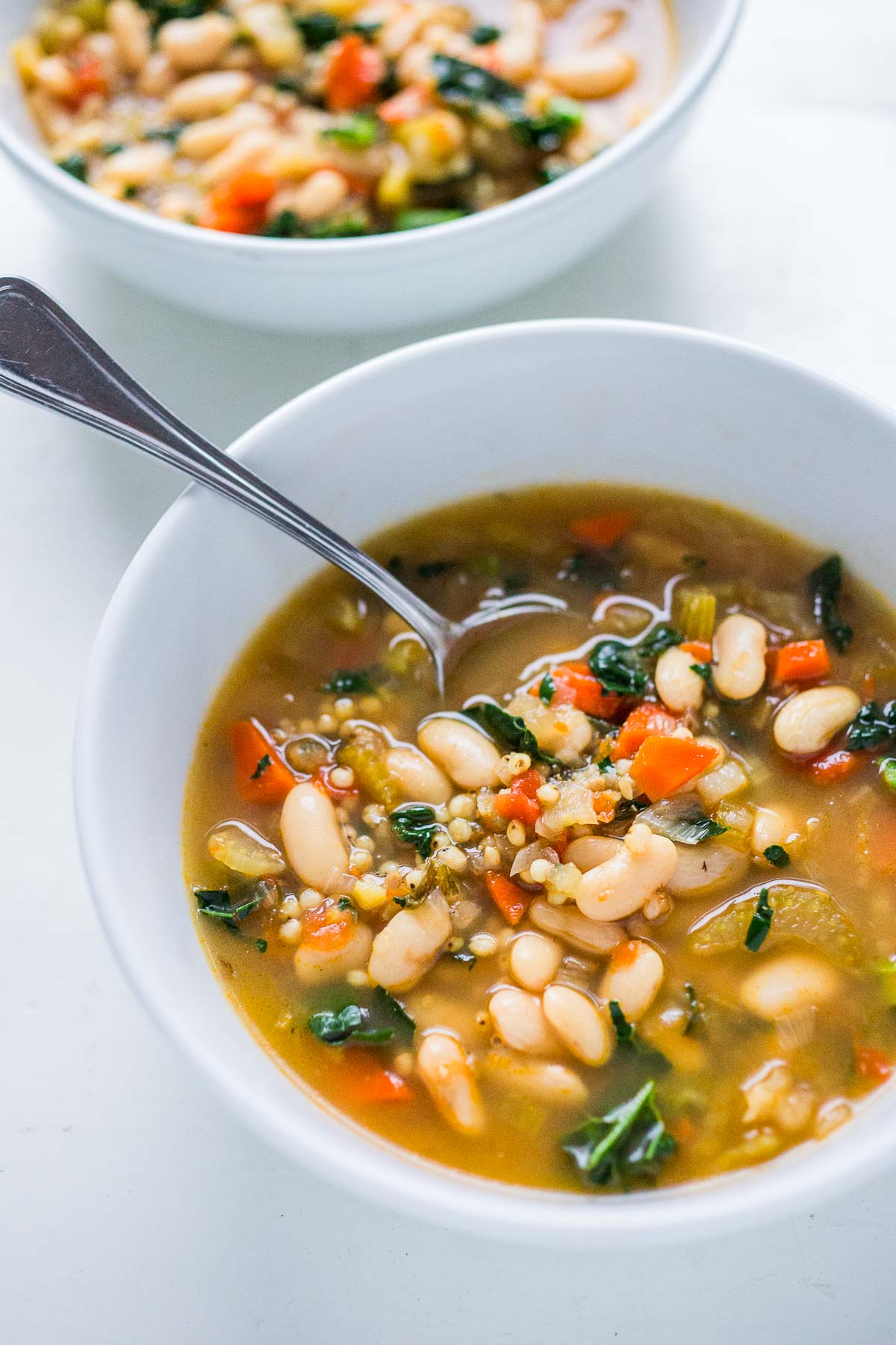 Sorghum soup in a white bowl with a spoon. 