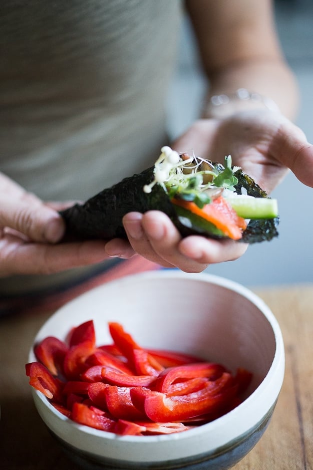 holding a temaki hand roll.