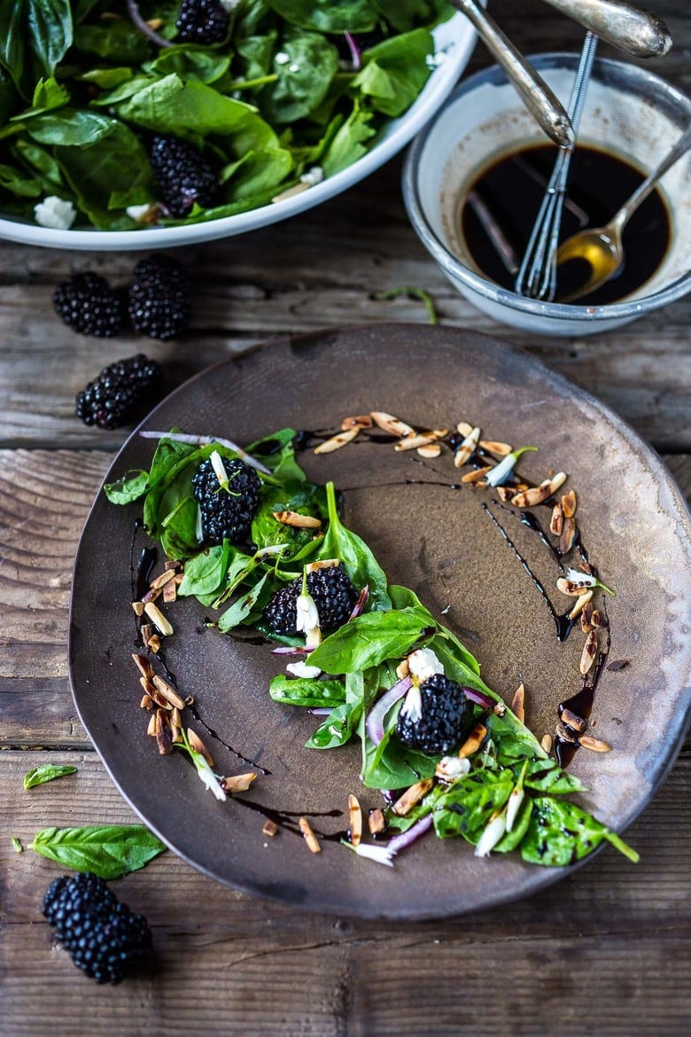 Fresh blackberry salad plated on a bronze plate.