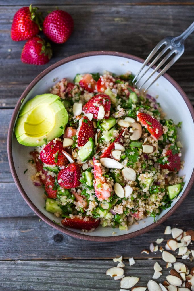 strawberry quinoa tabouli salad with almonds in a white bowl. 