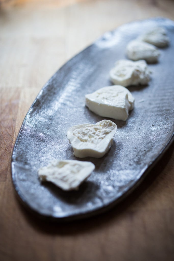 assembling the burrata salad on a platter.