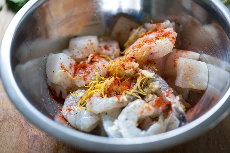 Prepping the fish with seasonings.