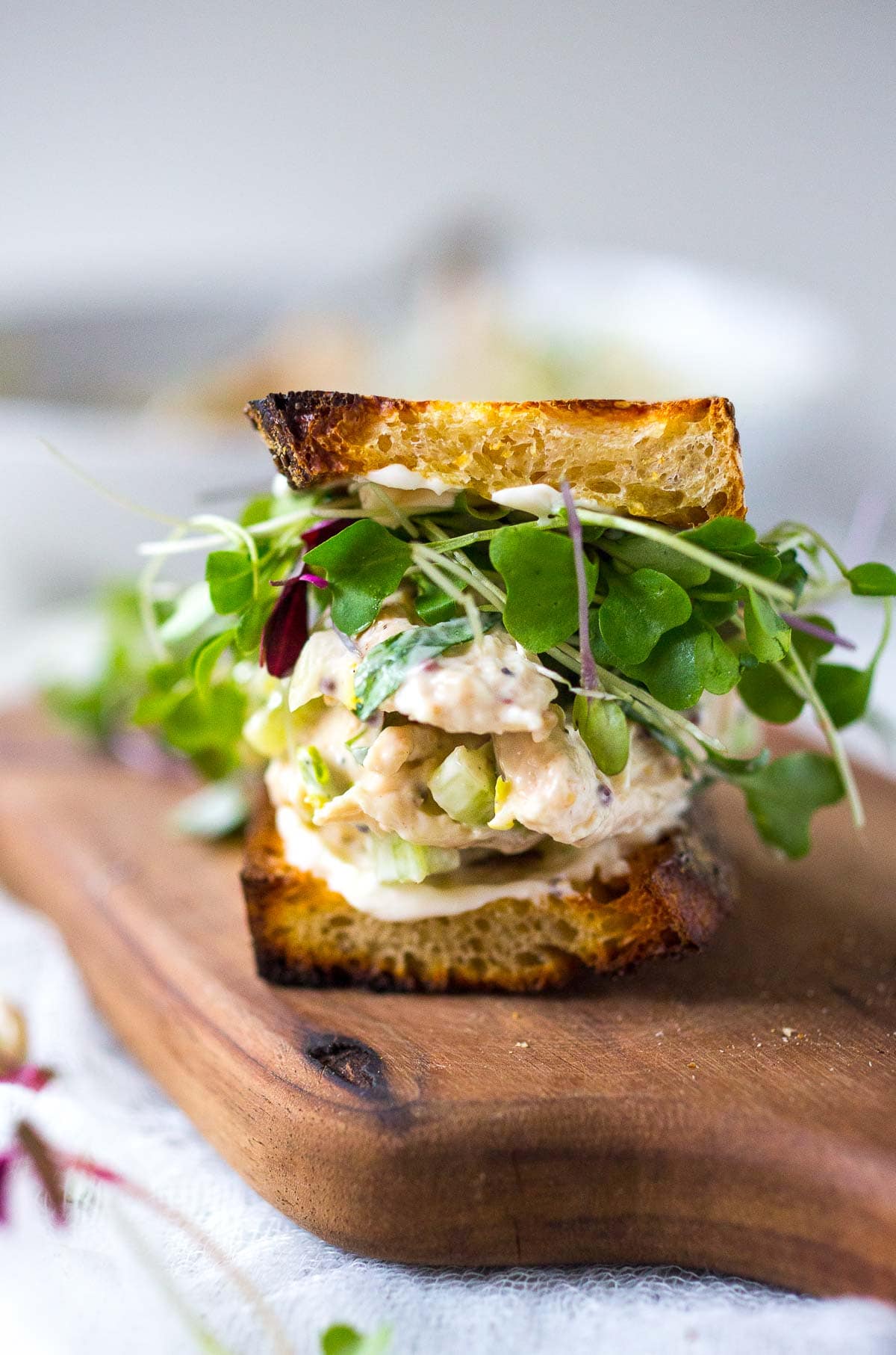 tarragon chicken salad sandwich on a cutting board. 