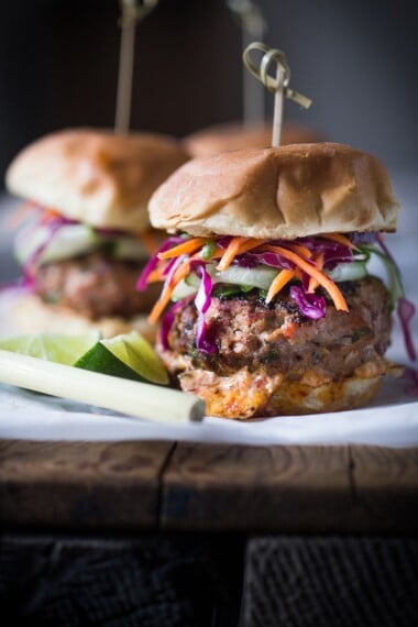 This irresistible turkey burger recipe is topped with crunchy Asian Slaw and bursts with Thai flavor! Use the grill, stovetop, or air fryer! www.feastingathome.com #thaiturkeyburger #thaiburger #turkeyburger #asianslaw #carrotslaw #healthyburger