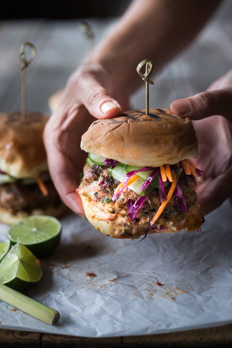 This healthy turkey burger recipe bursts with irresistible Thai flavor! Cook them on the grill, on the stovetop, or in your air fryer, then top with fresh and crunchy Asian slaw, cucumber ribbons, and sriracha aioli.  Gluten-free, made without bread crumbs. Video. Serve with Sweet Potato Fries.