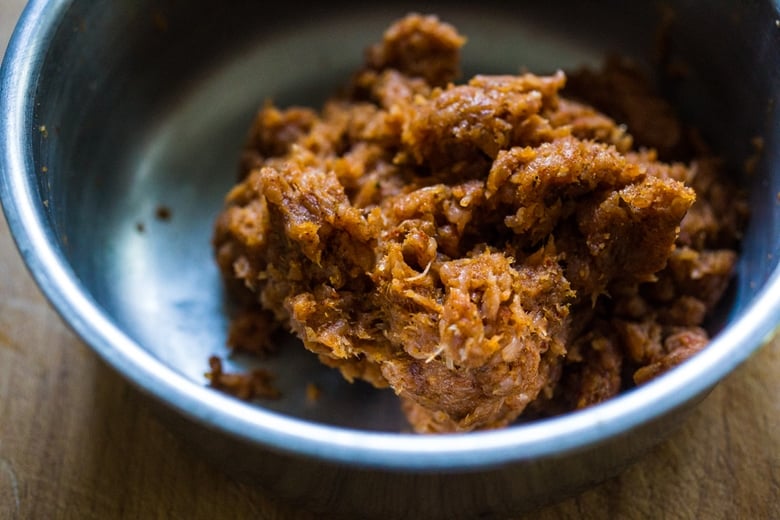 raw ground turkey mixing with seasonings in mixing bowl.