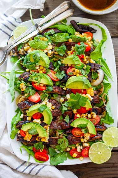 Grilled portobello mushroom salad on a white platter.