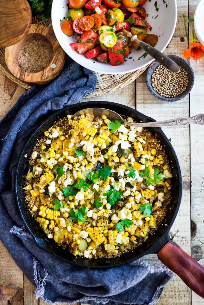 Baked quinoa recipe with corn and zucchini and feta cheese in a skillet. 