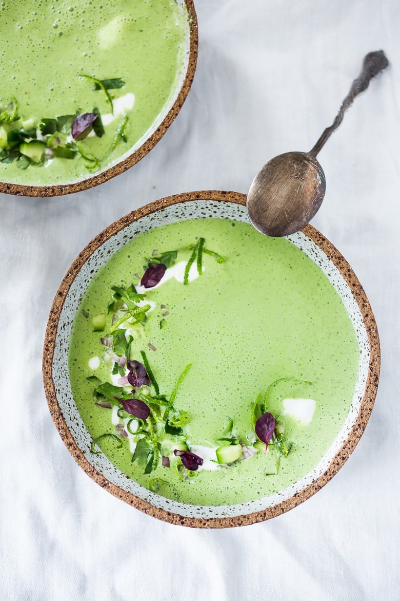 chilled cucumber gazpacho garnished with lime zest and herbs and a drizzle of yogurt.
