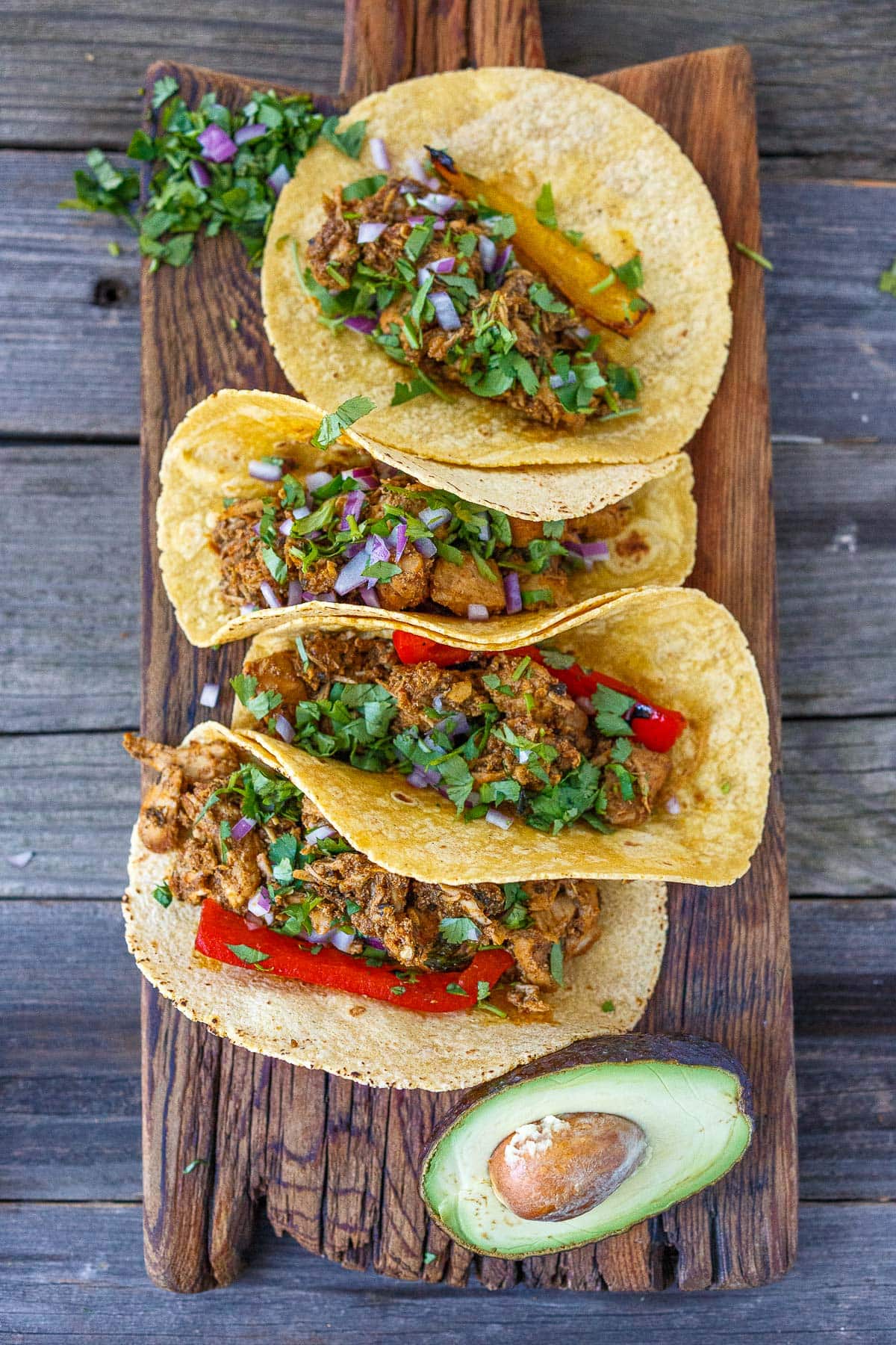 chicken carnitas tacos on a wood cutting board.