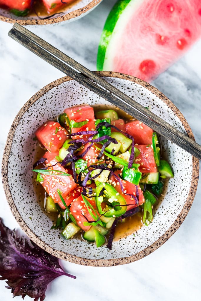 Watermelon cucumber Salad in a speckled bowl with chop sticks.