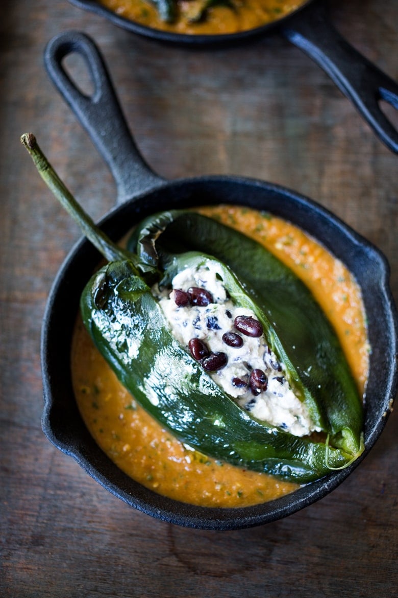 A healthy, vegan adaptable, Roasted Chiles Rellenos Recipe - that is lightened up with the addition of black beans. Simplified by roasting (instead of frying) the peppers with the Salsa Ranchero Sauce ingredients - all baked together on one sheet-pan - saving a step! #chiliesrancheros