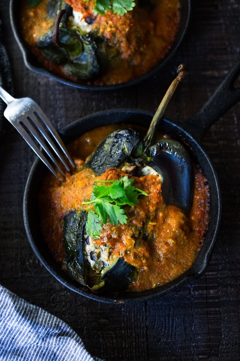 A healthy, vegan adaptable, Roasted Chiles Rellenos Recipe - that is lightened up with the addition of black beans. Simplified by roasting (instead of frying) the peppers with the Salsa Ranchero Sauce ingredients - all baked together on one sheet-pan - saving a step! #chiliesrancheros