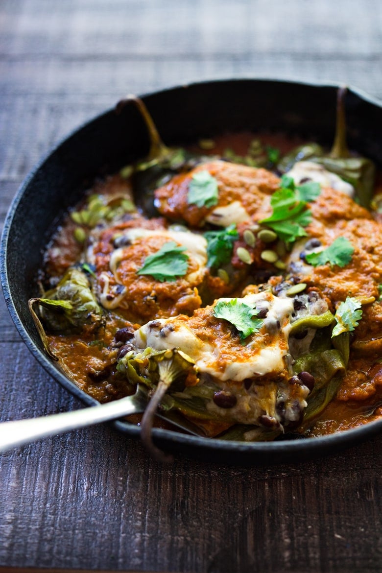 A healthy, vegan adaptable, Roasted Chiles Rellenos Recipe - that is lightened up with the addition of black beans. Simplified by roasting (instead of frying) the peppers with the Salsa Ranchero Sauce ingredients - all baked together on one sheet-pan - saving a step! #chiliesrancheros