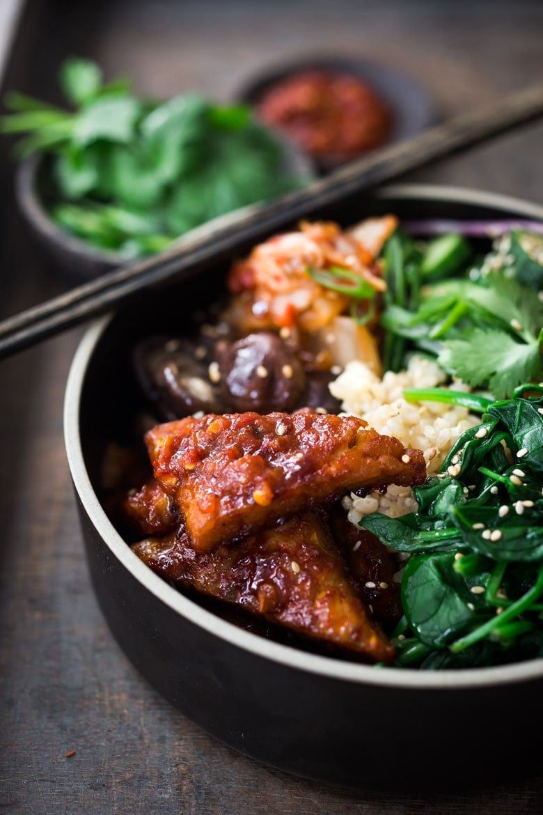 Vegan Bibimbap recipe (aka Seoul Bowl) with gochujang-baked Tempeh, steamed veggies, kimchi and quick pickled cucumbers.