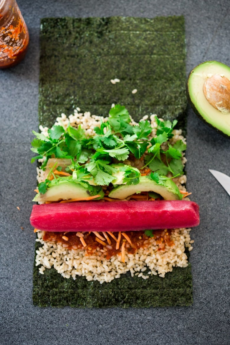 Filling and Rolling up a sushi burrito on the counter. 