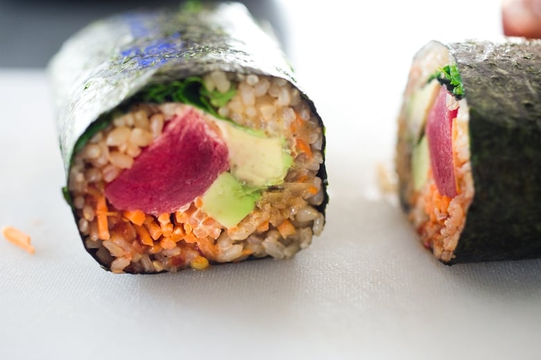 a sushi burrito cut in half. 