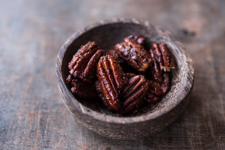 Chipotle Maple Pecans in tiny wood bowl.