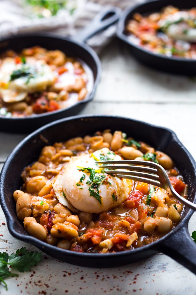 This Italian breakfast recipe is similar to one found in Tuscany. Eggs are gently poached over a savory cannellini bean and tomato stew, topped with Italian gremolata sauce. It's vegetarian. 