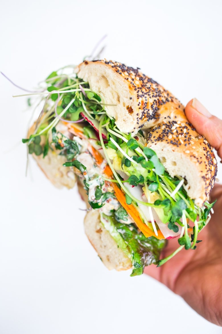  Vegan Chickpea Salad Sandwich with microgreens and avocado in a bagel. 