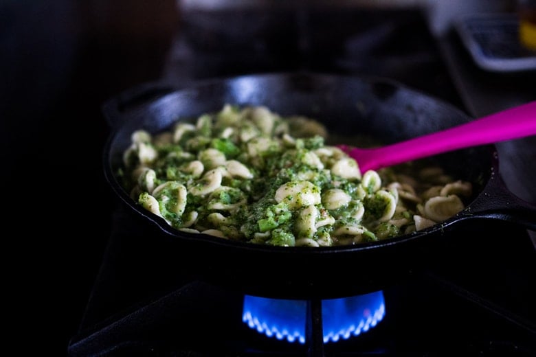 combining the broccoli sauce and the pasta in a skillet. 