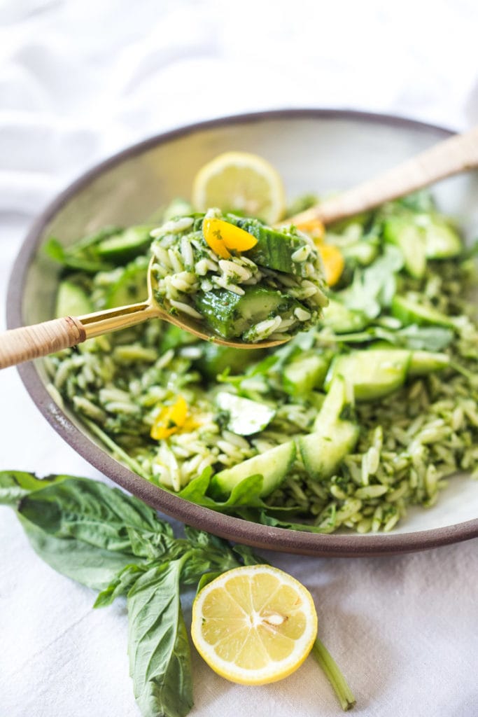 Cucumber Orzo Salad with Lemon & Basil in a bowl with salad utensils.