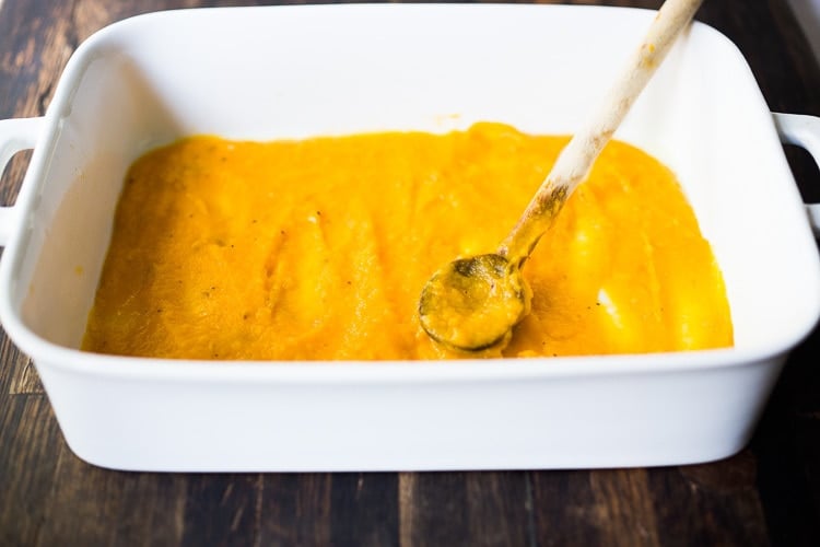 butternut sauce being spread onthe baking dish.