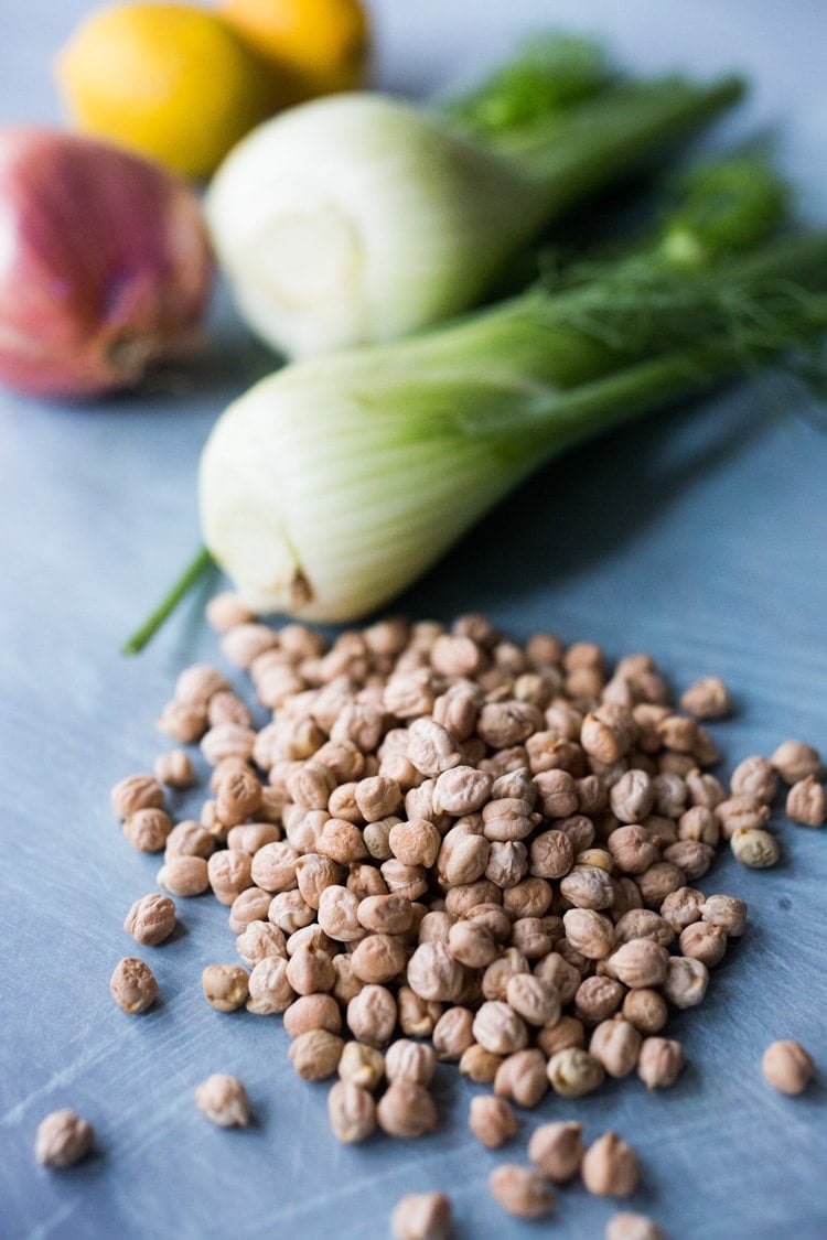 dried chickpeas on counter in front of fennel bulb. 