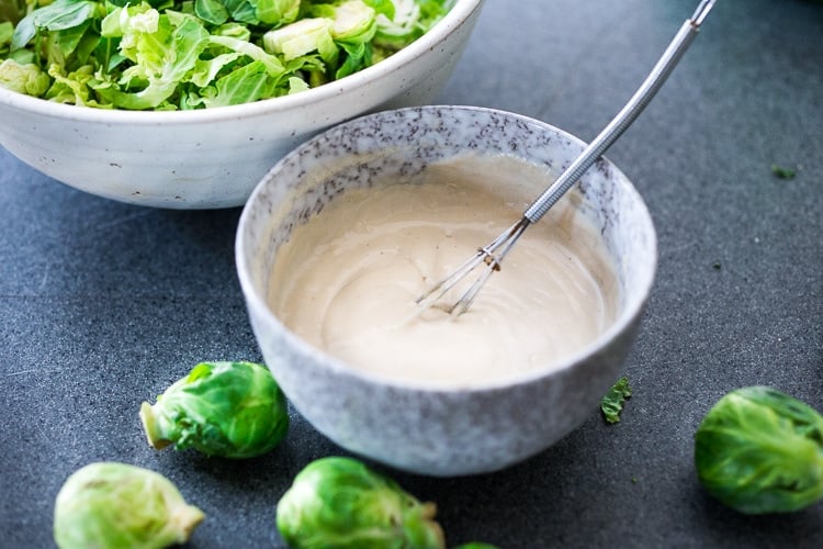 Lemony Brussel Sprout Salad with Creamy Tahini Sauce and Pistachios - a tasty, vegan salad that can be made ahead. Perfect for midweek lunches or potlucks or gatherings. #brusselsprouts #brusselsproutsalad #brusselsproutslaw #brusselsproutsrecipes #vegan #plantbased #cleaneating #eatclean #vegansalad 