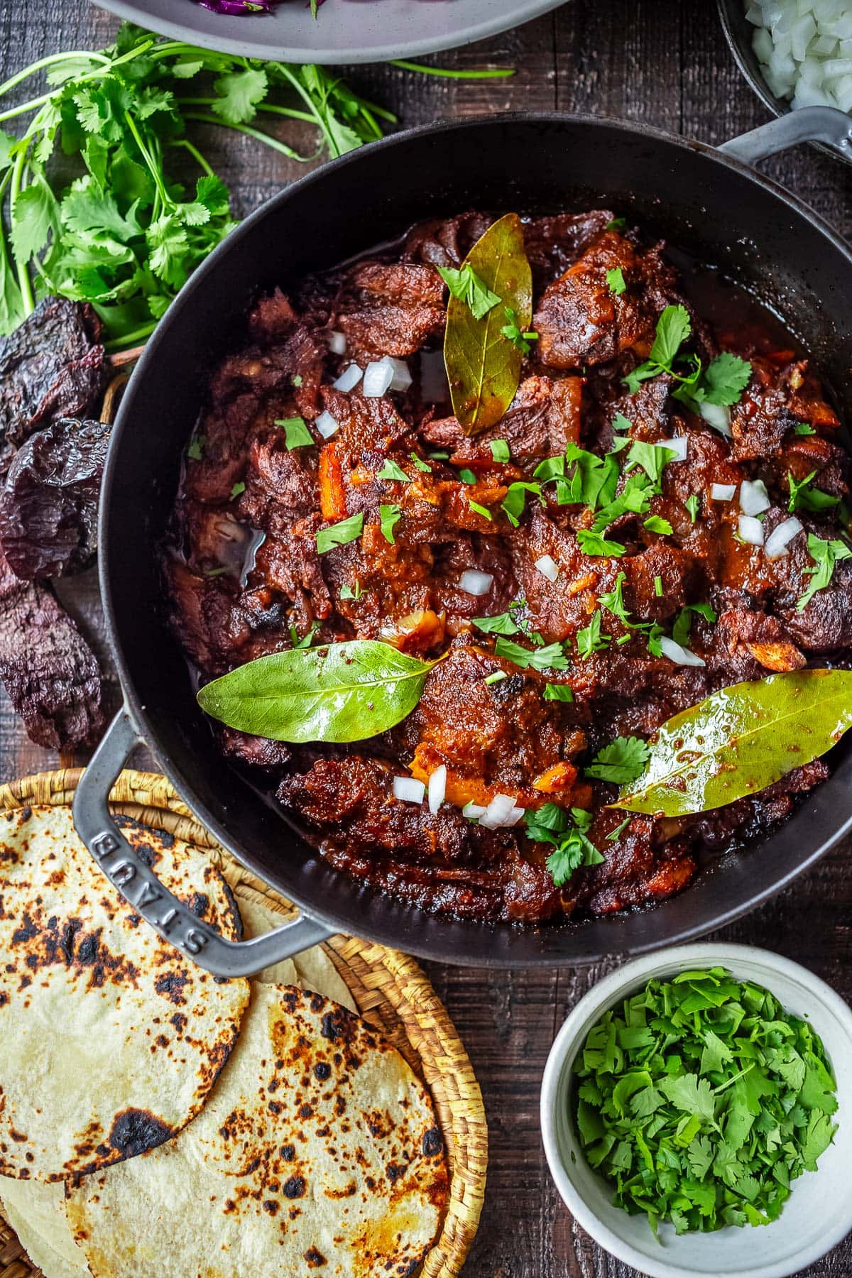 Barbacoa recipe in a dutch oven, tender and flavorful with cilantro and onions, ready for tacos.