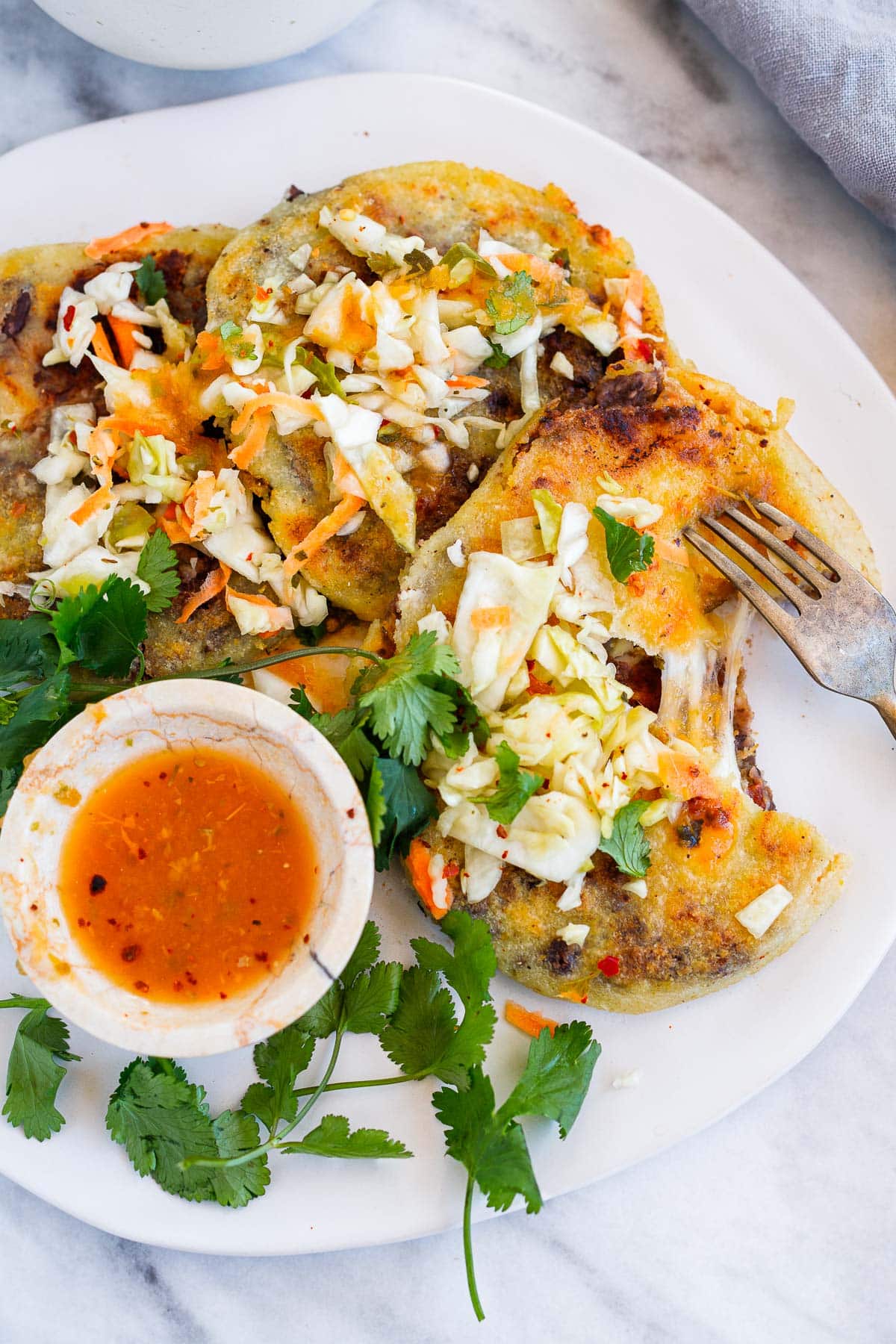 How to make Pupusas!  Pupusas are griddled Salvadoran cakes made with masa flour (or rice flour) filled with beans and cheese.  Serve pupusas with curtido and salsa roja- a simple, easy vegetarian version of pupusas, that is vegan-adaptable! Video.